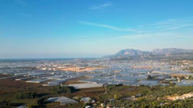 Bu hava görüntüsü, Türkiye dağlarının ve çarpıcı manzaranın ortasına kurulmuş dev bir sebze çiftliğinin güzelliğini yansıtıyor. Sonu gelmeyen yeşil bitki örtüsüyle çiftlik öne çıkıyor.