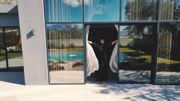 Arab Woman Dressed Black Abaya Shown Opening Curtains Villa Swimming — Vídeos de Stock