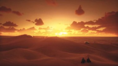 Video çölde destansı bir günbatımının nefes kesici güzelliğini yakalıyor. Gökyüzü turuncu, kırmızı ve sarı renklerle boyanarak geniş kum tepecikleri manzarasına karşı çarpıcı bir kontrast oluşturuyor.