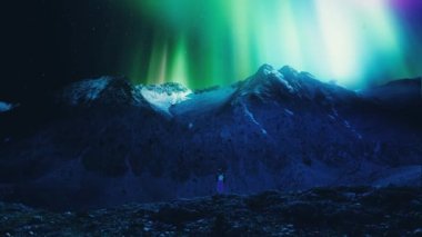 Kuzey Işıkları ya da Aurora Borealis ile kayanın tepesinde duran kadın turistler, güzel manzara. Yüksek kalite 4k görüntü