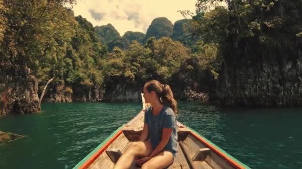 在热带石灰岩悬崖峭壁上 一个漂亮的旅行妇女坐在木制长尾船上的生活方式视频 探索和度假的概念 Khao Sok湖高质量的4K镜头 — 图库视频影像