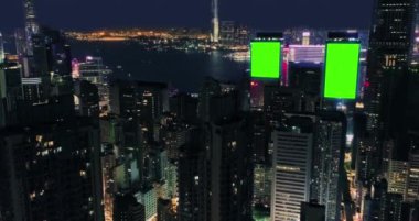 AERİAL. Gökdelenlerin üst görüntüsü ve izleme noktası olan yeşil ekran inşa panosu. Gece sokaklarında modern şehrin kuş bakışı. Yüksek kalite 4k görüntü