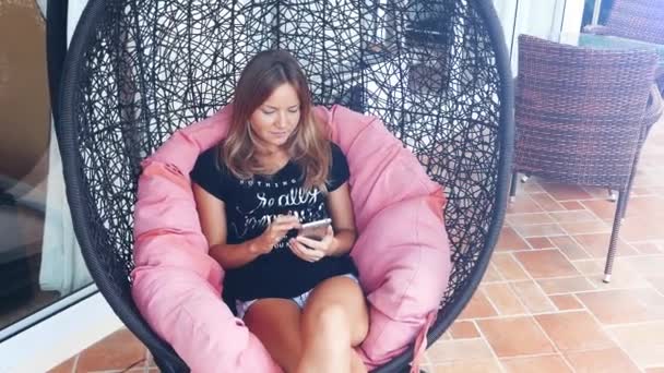 Молодая Женщина Используя Мобильный Смартфон Время Отдыха Hammock Летней Террасе — стоковое видео