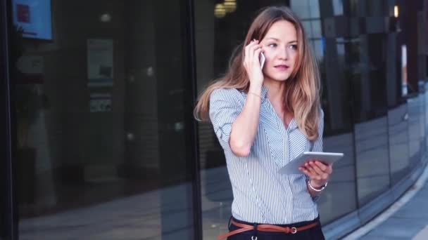 オフィスの外でタブレットとスマートフォンを使用する若いビジネス女性 高品質の4K映像 — ストック動画