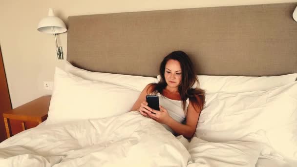 Молода Жінка Носить Повсякденну Білу Сорочку Лежачи Ліжку Відпочинок Розслабляється — стокове відео