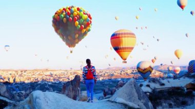 Kadın, Cappadocia 'da sıcak hava balonlarına bakıyor. Yüksek kalite 4k görüntü