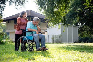 Tekerlekli sandalyedeki yaşlı çift, aşk ve özen, tekerlekli sandalyede oturan adam, yürüyemediği için kasvetliydi, boşluğu kopyaladı.
