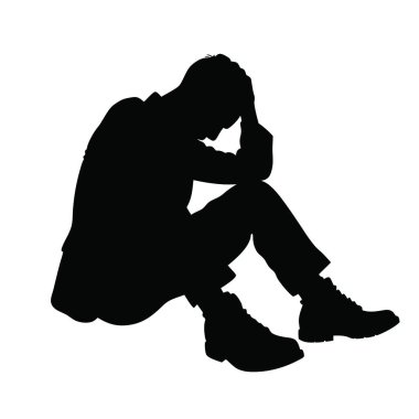 Kafası ellerinin arasında yerde oturan bir adam.