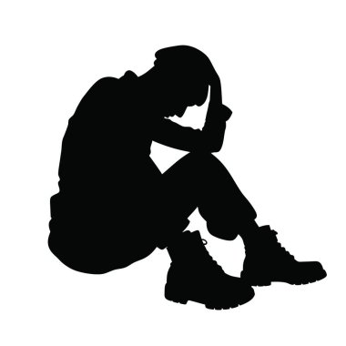 Kafası ellerinin arasında yerde oturan bir adam.