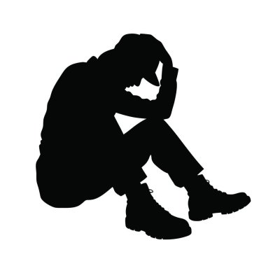 Kafası ellerinin arasında yerde oturan bir adam.