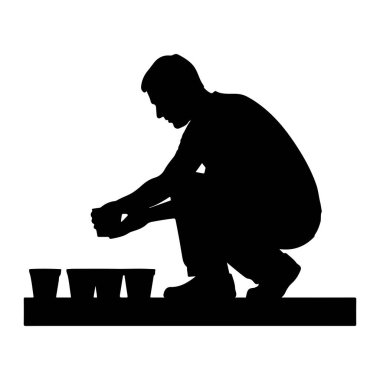 Çömelmiş bir adamın siyah silueti. Elinde bir şey tutuyor ve düz bir yüzeyde dizilmiş üç küçük çömleğe tohum ekiyor gibi görünüyor. Arkaplan beyaz.