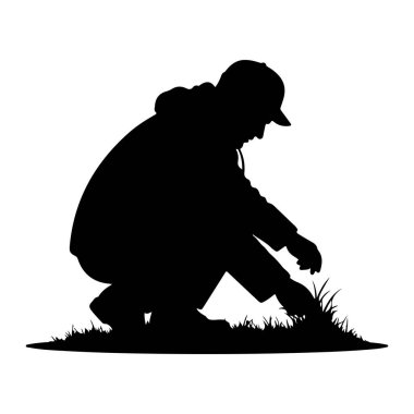 Siyah bir insan silueti, başını öne eğerek yere çömelmiş, çimenlerdeki bir şeyi inceler gibi tasvir edilir. Bu figür kapüşonlu bir elbise ve bir şapka giyer. Çim yaprakları keskin, detaylı çizgilerle kaplıdır.