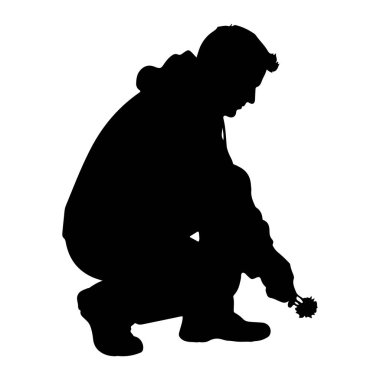 Bir kişinin siyah silueti, sanki bir şeyi incelermiş gibi başını eğerek çömelmiş bir şekilde tasvir edilir. Sağ elleri genişlemiş, küçük, sivri bir nesne tutuyorlar. Görünürde bir kapüşonlu ve pantolonlu olduğunu gösteren kıyafetler giyiyor.