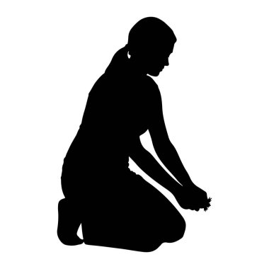 Siyah bir siluet. Diz çökmüş, yüzü aşağıya dönük ve ellerinde tutulan küçük bir nesneye bakıyor. Adamın saçları at kuyruğu şeklinde bağlanmış. Resim beyaz bir arkaplanda izole edilmiştir.