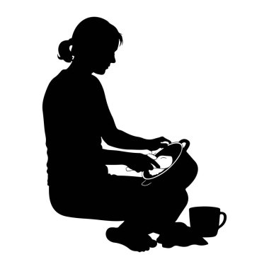 Yerde oturan, tencerede yemek hazırlamaya odaklanmış siyah bir kadın silueti. Elleri tencerenin içindekilerle aktif olarak meşgul ve bir kupa yakınlarda duruyor. Görüntü, beyaz bir arkaplan karşısında basit ve temiz bir resimdir.