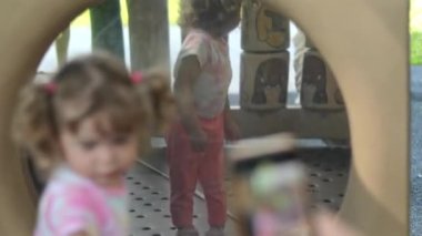 Mother taking picture of her little girl in front of big mirror at playground. High quality 4k footage