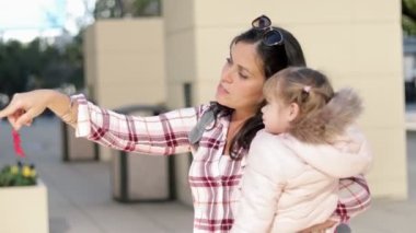 Beautiful shot of a mother and her little girl talking and hanging out outside