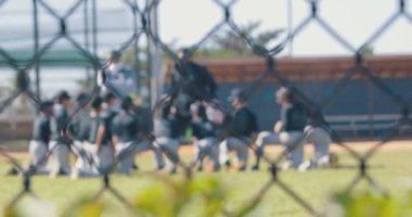Slow motion of a young baseball team getting pep talk from coaches while on the field. High quality 4k footage