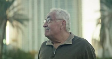 Üst sınıftan bir adamın parka bakarken orta profilli bir fotoğrafı.