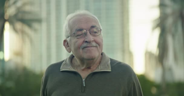 Senior Man Kijkt Rond Een Park Glimlacht — Stockvideo