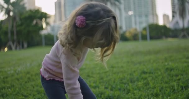 Zeitlupe Eines Kleinen Mädchens Beim Spielen Einem Park Mit Gebäuden — Stockvideo