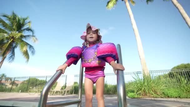 Kleines Mädchen Mit Schwimmwesten Und Hut Steht Vor Einem Swimmingpool — Stockvideo