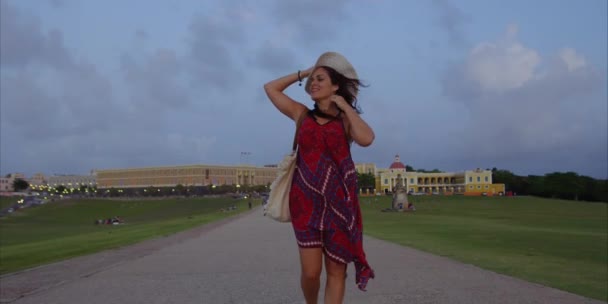 彼女の髪と帽子で遊んでいる間 サンフアン プエルトリコのエルモロに向かって歩く女性観光客の美しいスローモーションショット — ストック動画