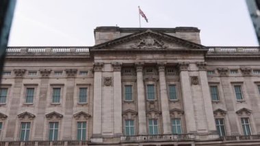 Buckingham Sarayı 'nın yakın çekim görüntüsü ve sonra kamera kapıdan dışarı çıkıyor.