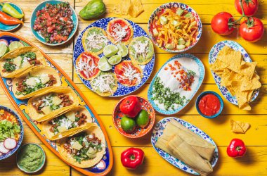 Bağımsızlık Günü için Meksika bayramı yemeği - Bağımsız Chiles en nogada, tacos al pastor, chalupas pozole, tamales, köstebek soslu tavuk. Sarı arkaplan