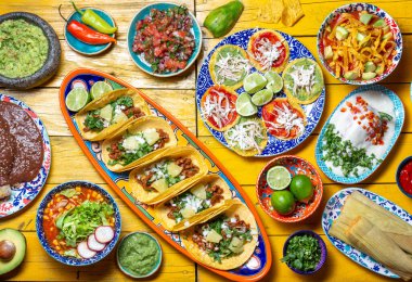 Bağımsızlık Günü için Meksika bayramı yemeği - Bağımsız Chiles en nogada, tacos al pastor, chalupas pozole, tamales, köstebek soslu tavuk. Sarı arkaplan