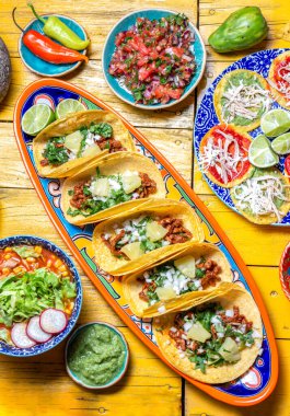 Bağımsızlık Günü için Meksika bayramı yemeği - Bağımsız Chiles en nogada, tacos al pastor, chalupas pozole, tamales, köstebek soslu tavuk. Sarı arkaplan