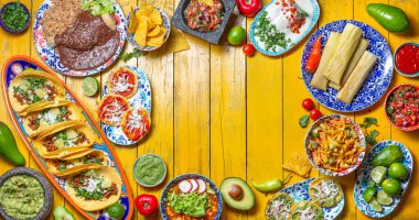 Bağımsızlık Günü için Meksika bayramı yemeği - Bağımsız Chiles en nogada, tacos al pastor, chalupas pozole, tamales, köstebek soslu tavuk. Sarı arkaplan