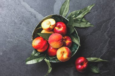 Şeftali ağacı ile taze olgun şeftali yeşil kapta, üstten görünüm bırakır.