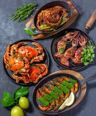 Bir dizi deniz ürünleri tabağı. Siyah arka planda yengeç, ahtapot, mürekkep balığı ve kaplan karidesleri var. Üst görünüm