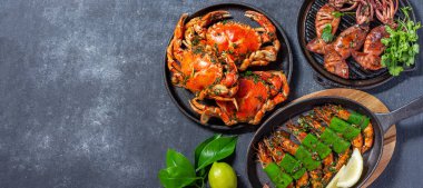 Bir dizi deniz ürünleri tabağı. Siyah arka planda yengeç, ahtapot, mürekkep balığı ve kaplan karidesleri var. Üst Manzara. Metin için alanı kopyala