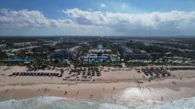 Beyaz kum plajı ve mavi okyanus kıyısındaki havuzları ve restoranları olan eğlence alanı güzel bir manzara. Hard Rock Hotel - Punta Cana Dominik Cumhuriyeti, Şubat 2022.