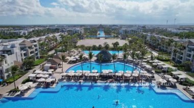 Beyaz kum plajı ve mavi okyanus kıyısındaki havuzları ve restoranları olan eğlence alanı güzel bir manzara. Hard Rock Hotel - Punta Cana Dominik Cumhuriyeti, Şubat 2022.