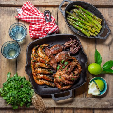 Izgara şempanzeler, mürekkep balıkları ve ahtapot dökme demir tavada..