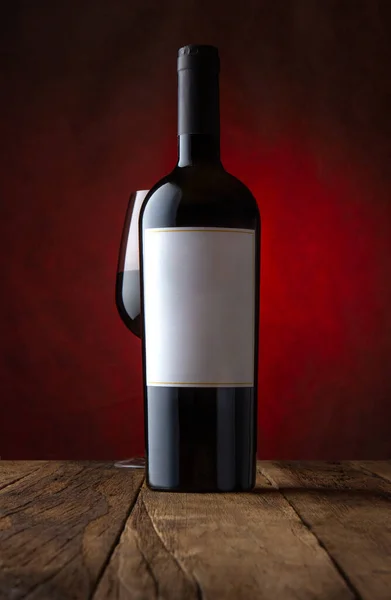 ガラスと赤ワインのボトルのプロモーションショット 空のラベル錆ついた茶色の背景 モックアップ フロントビュー — ストック写真