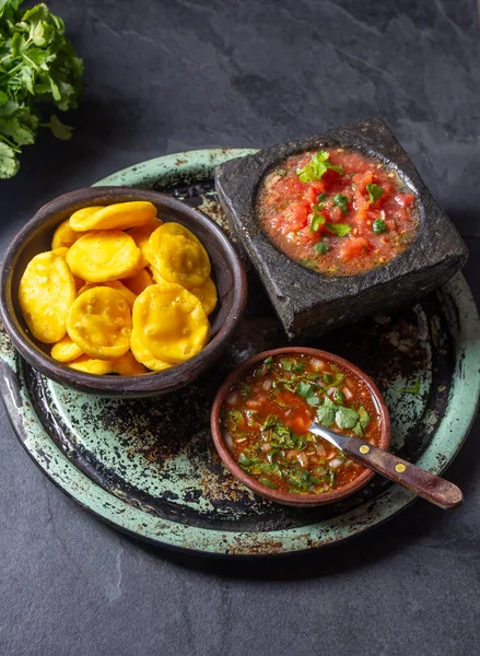 Sopaipilla. Latin American food. Traditional chilean homemade pumpkin sopaipillas with typical salsas - chancho en piedra tomato sauce in stone mortar and spicy pebre.