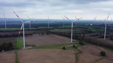 Mor bir akşam manzarasında rüzgar türbini eko çiftliği. Yeşil ekolojik dünya için yenilenebilir enerji üretimi. Rüzgar değirmenlerinin çiftlik parkının havadan görünüşü.