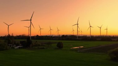 Günbatımında rüzgar türbinleri çiftliğinin insansız hava aracı görüntüsü. Yenilenebilir enerji üretimi.