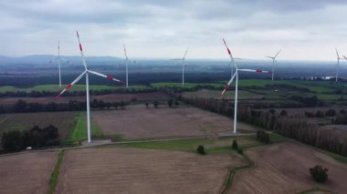 Mor bir akşam manzarasında rüzgar türbini eko çiftliği. Yeşil ekolojik dünya için yenilenebilir enerji üretimi. Rüzgar değirmenlerinin çiftlik parkının havadan görünüşü.