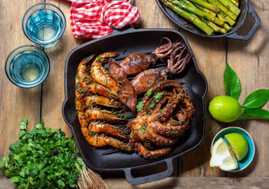 Izgara şempanzeler, mürekkep balıkları ve ahtapot dökme demir tavada..