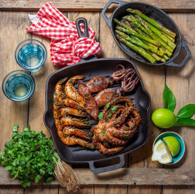 Izgara şempanzeler, mürekkep balıkları ve ahtapot dökme demir tavada..