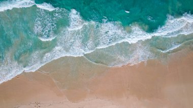 Dominik Cumhuriyeti 'nde el değmemiş bir plajın nefes kesici hava manzarası. Turkuaz dalgaların yumuşak altın kumlara çarpması. Temiz su ve yumuşak sörfler dingin ve davetkar bir hava yaratır.