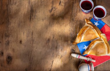 Şili 'nin bağımsızlık günü kavramı. fiestas patrias. Tipik pişmiş börek, şarap ya da Chicha, şişman ve embolik. 18 Eylül parti günü için dekorasyon, ahşap arka plan, üst manzara.