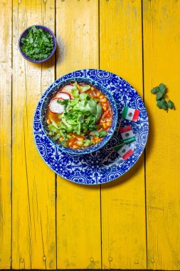 Lezzetli Pozole çorbası Meksika Bağımsızlık Günü için taze malzemelerle dolu renkli bir kasede servis ediliyor..