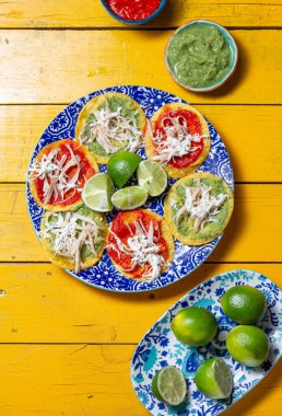 İçi doğranmış tavuk ve renkli malzemelerle dolu canlı bir Meksika chalupası tabağı geleneksel mutfağın zengin lezzetlerini gözler önüne seriyor..