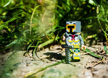 Minecraft lego şövalyesi çimenlerde kılıç taşıyor.
